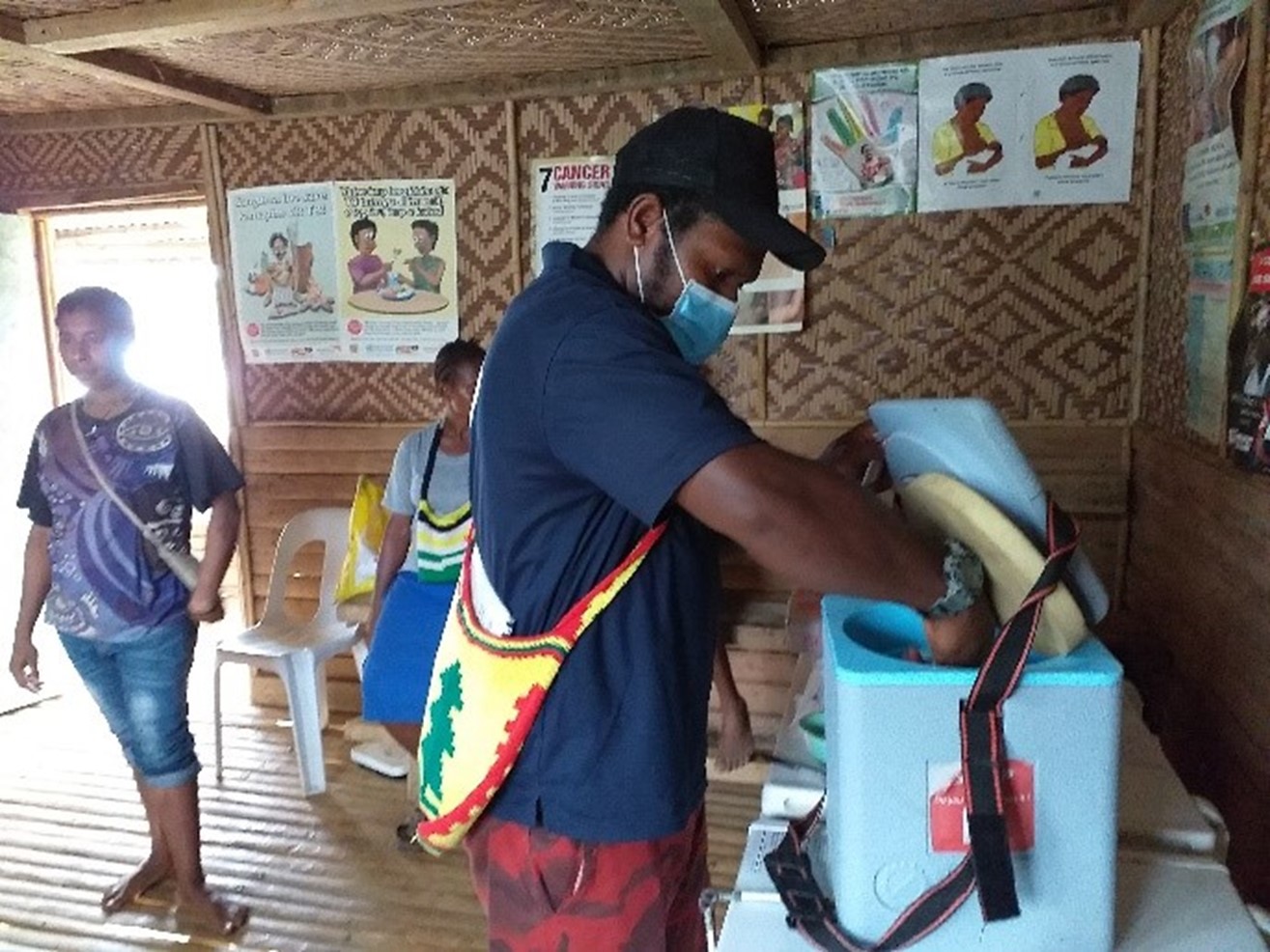 AHP health worker handling the vaccine transporter_photo credit_SDP. Kacific satellite internet. Papua New Guinea. PNG. Sustainable development programme