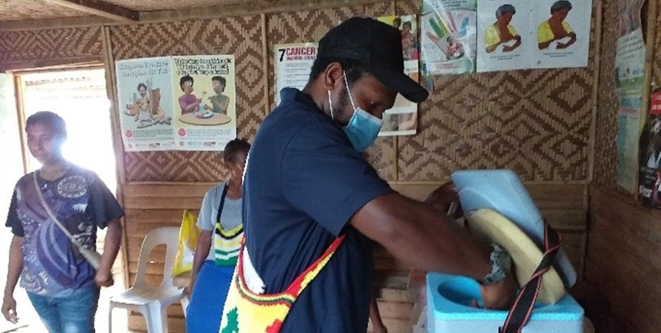 Health worker managing a vaccine transporter